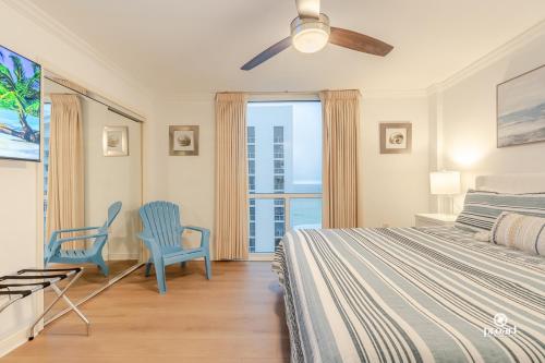 a bedroom with a bed and two blue chairs at BEACHFRONT - Huge, 3BDR-2BA condo Sleeps 10 people, Great for Groups in Destin