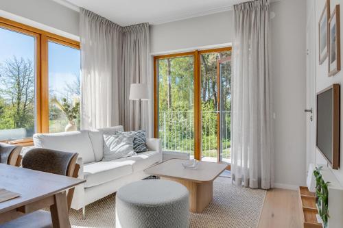 a living room with a white couch and a table at Cozy, designed, Beach House apartment in Beddinge Strand