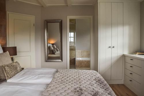 a bedroom with a bed and a sink and a mirror at Haus Lang Libben in Archsum