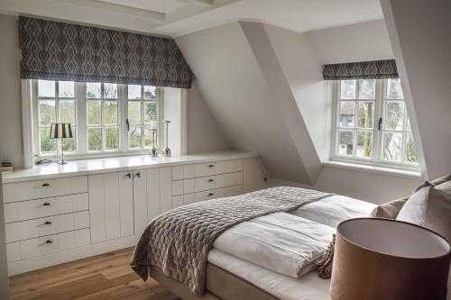 a bedroom with a bed and two windows at Haus Lang Libben in Archsum