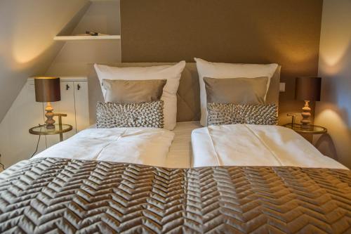 a bedroom with a large bed with two pillows at Haus Lang Libben in Archsum