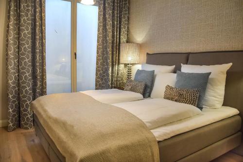 a bedroom with a large bed with pillows at Haus Lang Libben in Archsum