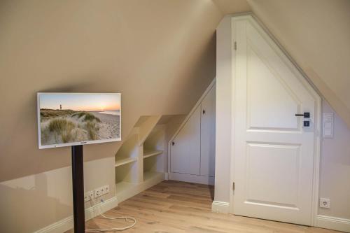 a room with a picture of a beach on the wall at Haus Lang Libben in Archsum