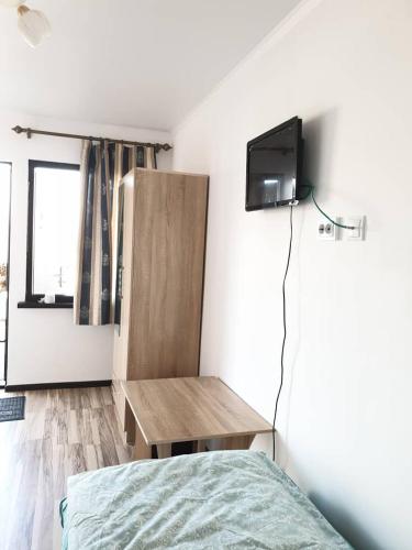 a bedroom with a bed and a tv on a wall at Moonlight in Cholpon-Ata