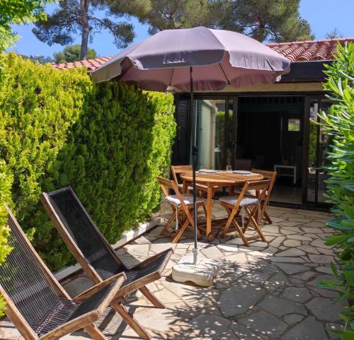 une table et des chaises avec un parasol sur une terrasse dans l'établissement Studio 24m2 - parking - clim - piscine - plage 50m, à Roquebrune-sur Argens