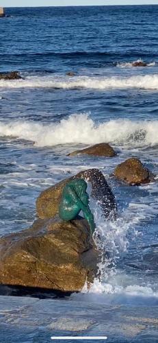 a person laying on a rock in the ocean at Notre paradis in Lumio