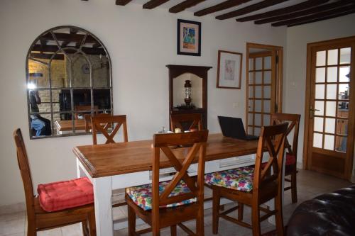 une salle à manger avec une table et des chaises en bois dans l'établissement Charming 17th Century Normandy Longere in Valdallière, Calvados, à Le Theil