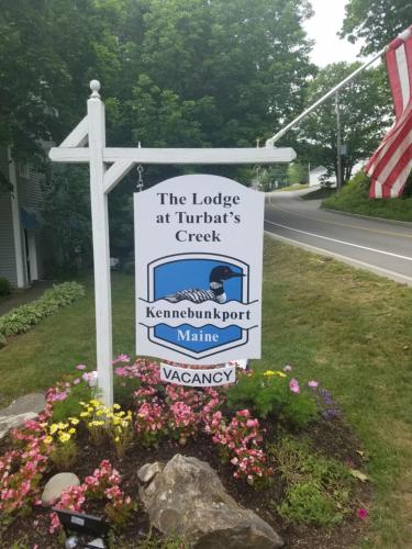 a sign on the side of a road with flowers at The Lodge at Turbat's Creek in Kennebunkport
