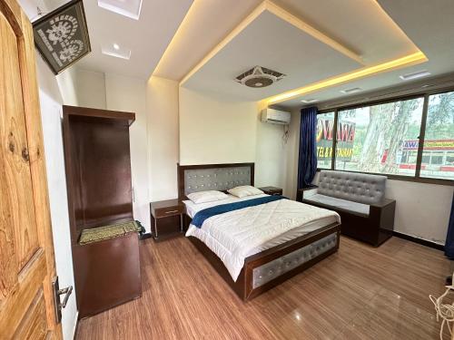 a bedroom with a bed and a large window at Mawa Hotel Balakot in Bisiān
