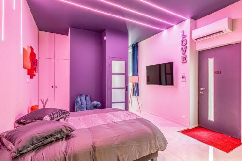 - une chambre violette avec un lit et une télévision dans l'établissement Vienne, à Lyon