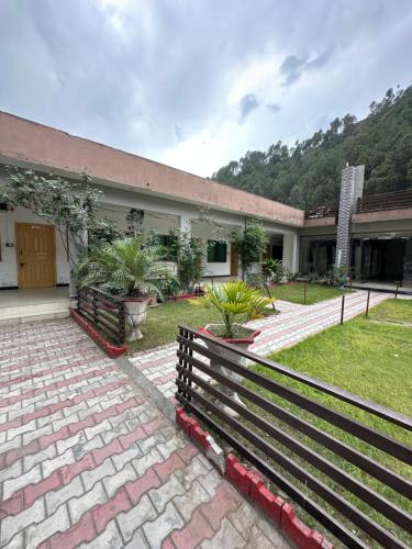 a building with a fence in front of a yard at Mawa Hotel Balakot in Bisiān