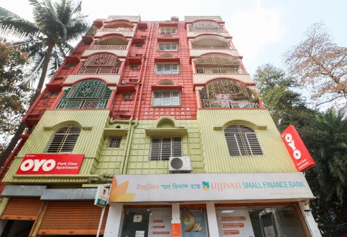 a tall yellow and red building on a street at Super Hotel O Adri Hotels in Kolkata