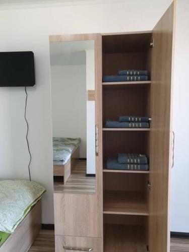 a room with a bed and a wooden book shelf at Moonlight in Cholpon-Ata