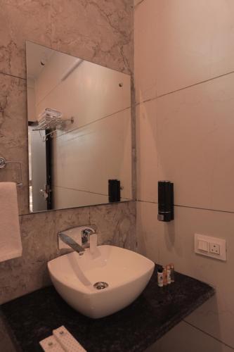 a bathroom with a white sink and a mirror at Yogved Hospitality & Resort in Rishīkesh