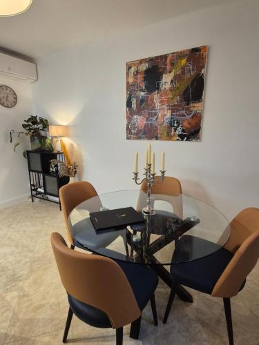 une salle à manger avec une table et des chaises en verre dans l'établissement Appartement Aux 3 Sens, à Sarlat-la-Canéda