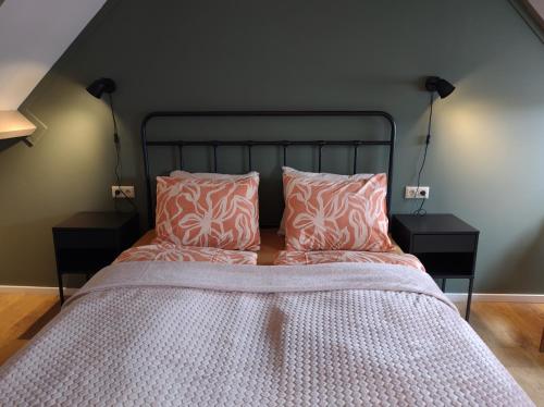 a bedroom with a bed with pink and white pillows at 't KISTJE Bed by the Sea in Koudekerke