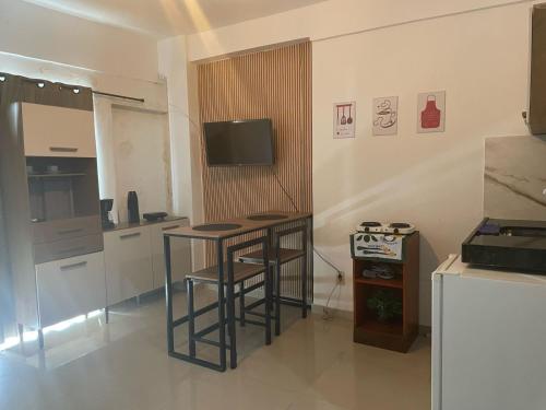 a kitchen with a table and stools in a room at Mini loft mobiliado in Belém