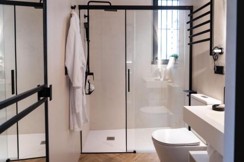a bathroom with a toilet and a glass shower door at Las Amiras Homes Collection in Granada