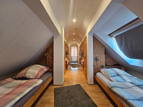 two beds in a room with an attic at Fewo-O3-4-6-Personen-23km-bis-Frankfurt-Nord in Ober-Mörlen