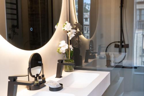 a bathroom with a sink and two mirrors at Las Amiras Homes Collection in Granada