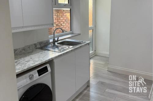 una cocina con fregadero y lavavajillas en OnSiteStays - 4 bedroom house with 2 bathrooms, en Welling