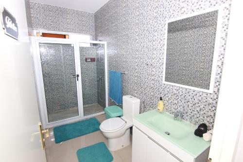 Un baño con inodoro, lavabo y ducha. en Villa Racine, en Porto Novo