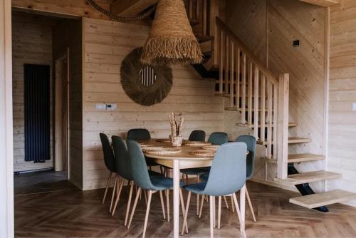 a dining room with a table and blue chairs at Jodełkowa Stodoła in Tylmanowa