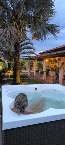 a woman in a hot tub with a palm tree at Spa Belo Quinto Prime in Brotas