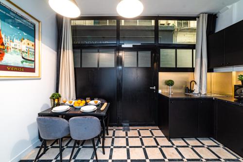 - une cuisine avec une table et deux chaises dans une pièce dans l'établissement Triplex 50 m2 - Montorgueil & Marais, à Paris