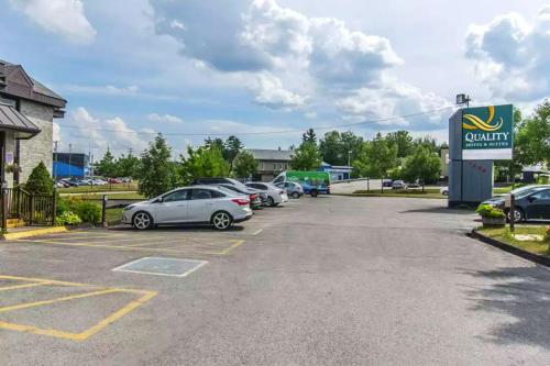 a parking lot with cars parked in front of a car dealership at Quality Hotel & Suites in Sherbrooke