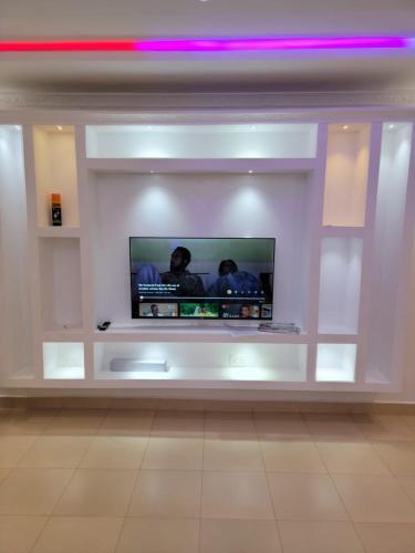 a flat screen tv in a white wall at Rumkin Homes in Lotus Island