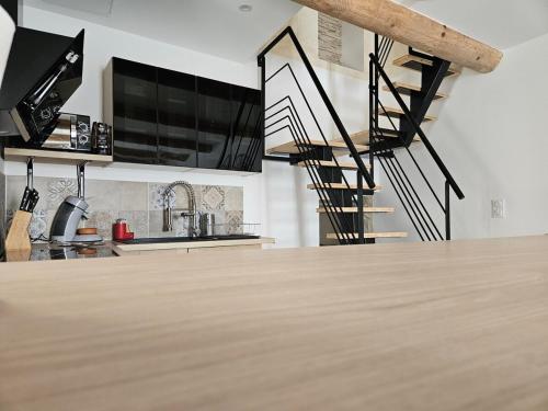 une cuisine avec un comptoir en bois et un escalier en colimaçon dans l'établissement LA VASIO Hypercentre Vaison-la-Romaine - Air-conditioned, à Vaison-la-Romaine