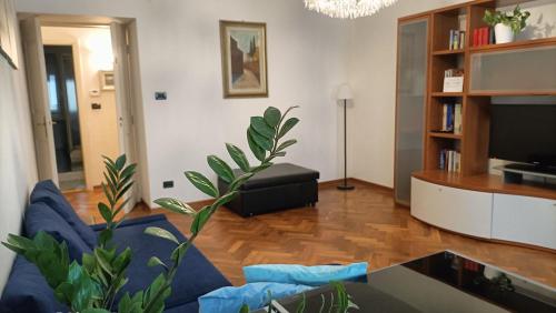 een woonkamer met een blauwe bank en een tv bij Galleria sul Mare in Trieste