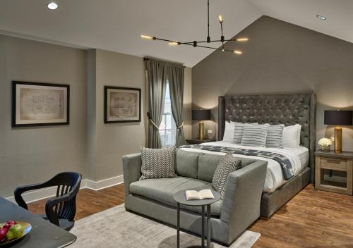 a bedroom with a bed and a couch and a table at The Inn at Chesapeake Bay Beach Club in Stevensville