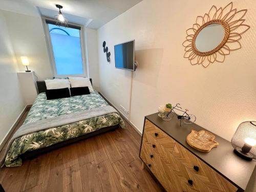 une petite chambre avec un lit et un miroir dans l'établissement Montbel'appart - Le Central studio, à Montbéliard