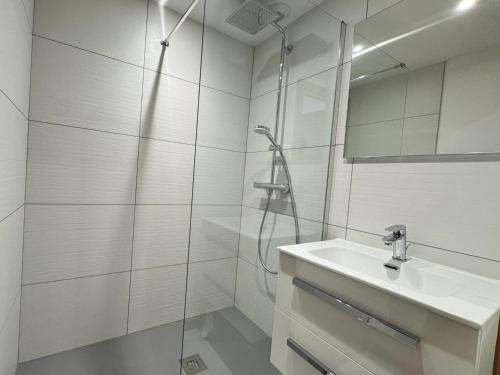 a white bathroom with a sink and a shower at Appartement cosy 3 pièces, pied des pistes, parking, Pralognan - FR-1-464-242 in Pralognan-la-Vanoise