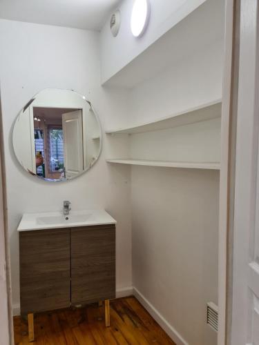 une salle de bain avec un lavabo et un miroir dans l'établissement Studio cosy avec clim et jardin, à Fontaine