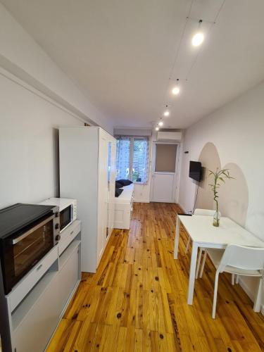 un salon avec une table et une cuisine dans l'établissement Studio cosy avec clim et jardin, à Fontaine