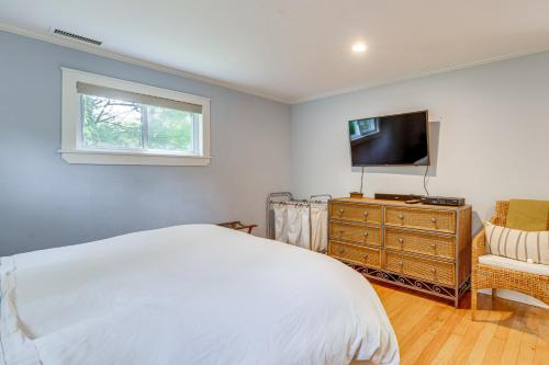 a bedroom with a bed and a television and a chair at Hamptons Vacation Rental with Seasonal Pool! in Hampton Bays