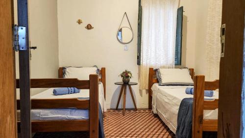 a bedroom with two beds and a mirror at Casa Andorinha in Lençóis