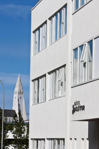 a white building with a sign on the side of it at Hotel Klettur in Reykjavík