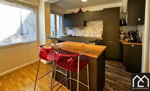 une cuisine avec un comptoir et deux tabourets de bar rouge dans l'établissement La Parisienne entre ville et port 6pers - stationnement, à Boulogne-sur-Mer