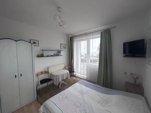 a bedroom with a bed and a window at Pod Kogutami Chałupy in Chałupy