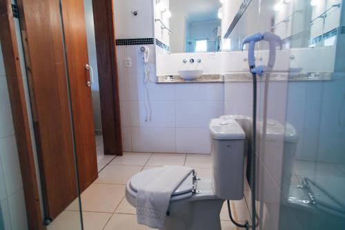 a bathroom with a toilet and a sink at Plaza Inn Week Inn in Campos do Jordão