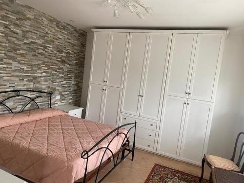 a bedroom with a bed and a brick wall at Appartamento 'Diva Canova Laguna Veneta' in Santa Margherita