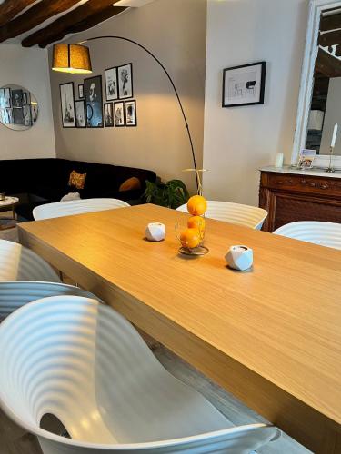 a dining room table with a lamp and oranges on it at 3 chambres Centre Fontainebleau Château INSEAD - Royal Deluxe in Fontainebleau
