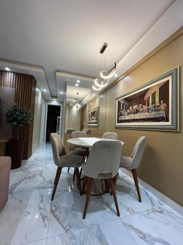 a dining room with a table and chairs and a painting at Torres Devant in Belém
