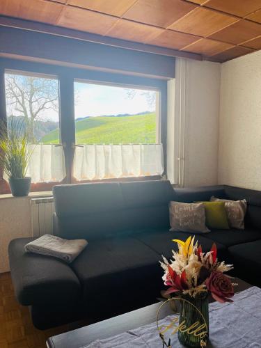 a living room with a blue couch and a window at Apartma Špan in Zgornje Gorje