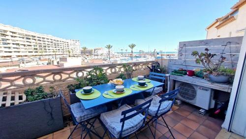 - une table bleue sur un balcon avec vue sur la plage dans l'établissement Le Chrystina - T2 au port avec terrasse vue mer - Parking WIFI clim, à Saint Cyprien Plage