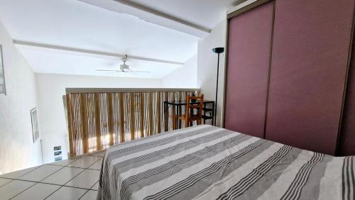 - une chambre avec un grand lit et une porte violette dans l'établissement Le Chrystina - T2 au port avec terrasse vue mer - Parking WIFI clim, à Saint Cyprien Plage